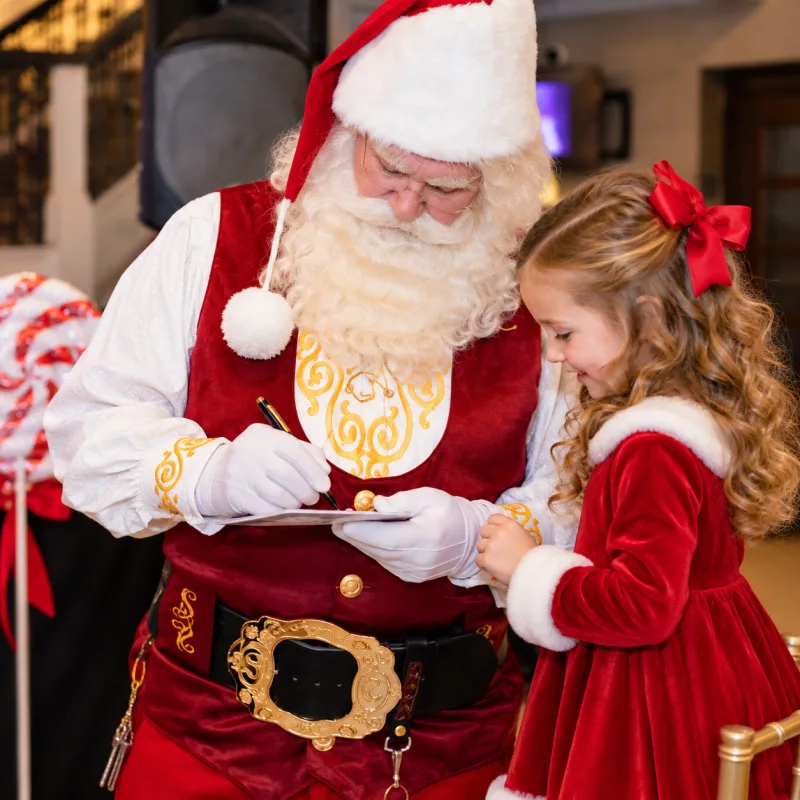 Santa signing an autograph for a child